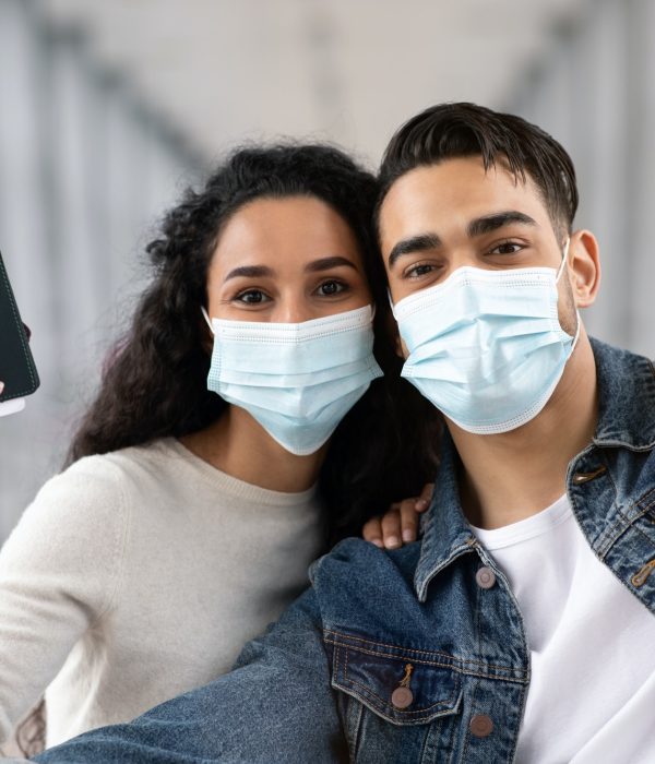 planning your trip - COVID-19 Travels. Happy Arab Couple In Medical Mask Taking Selfie In Airport